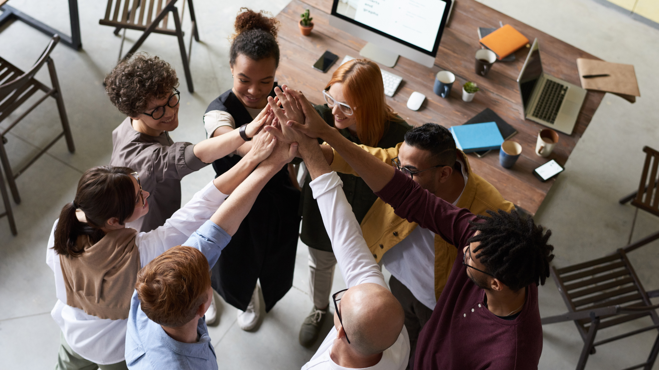 A group of workers joining hands in a circle